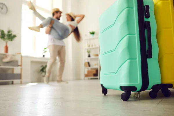 Närbild av två resväskor står på golvet med par kär har roligt i bakgrunden — Stockfoto