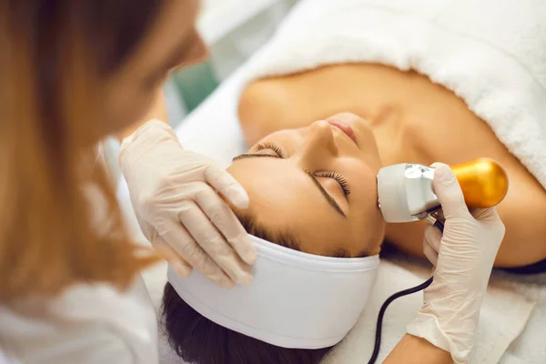 Mãos de cosmetologista fazendo drenagem linfática do rosto para a mulher no salão de spa — Fotografia de Stock