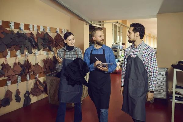 Designer de calçado ou gerente de produção falando com o grupo de trabalhadores da fábrica de calçados — Fotografia de Stock
