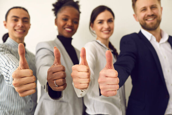 Thumbs up recommend gesture showing by diverse business team positive people