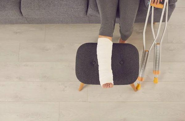 Női sérült láb lazító széklet öntött és fém mankók — Stock Fotó