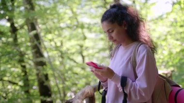 Kadın yürüyüşçü seyrüsefer için cep telefonu kullanıyor, internetten bilgi arıyor