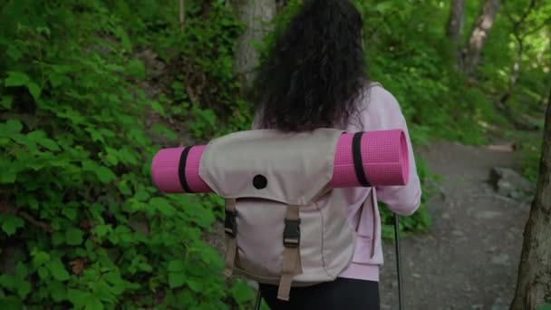 Жінка мандрівник з пішохідними полюсами в лісі — стокове відео