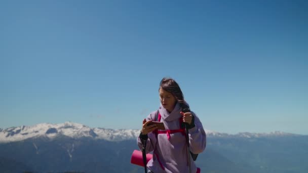 Toeristische vrouw is oriënteren door elektronische kaart in mobiele telefoon in de bergen — Stockvideo