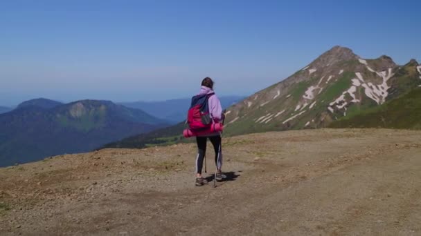 Hiking in mountain, young woman tourist is walking and carry backpack, traveling alone — Stok Video