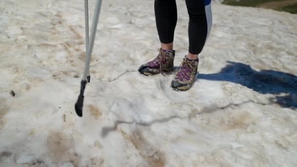 Πεζοπόρος με πασσάλους πεζοπορίας στην χιονισμένη πλαγιά — Αρχείο Βίντεο