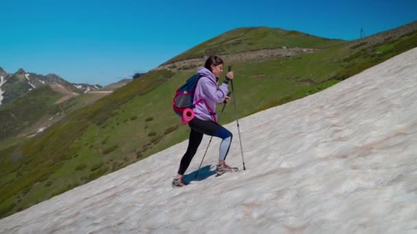 Κορίτσι ορειβάτης αναρρίχηση χιονισμένη πλαγιά — Αρχείο Βίντεο