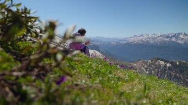 Yamacın yamacında dinlenirken telefonu kullanan bir kız.