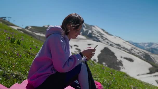 Vrouw genieten van eenzaamheid in de bergen en ontspannen met mobiele — Stockvideo