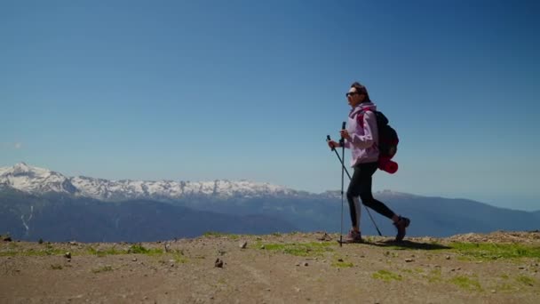 Уверенная в себе молодая женщина-туристка идет на гору, треккинг с шестом — стоковое видео