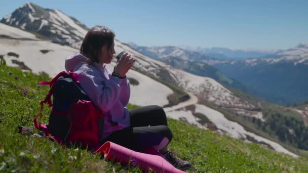 Backpackerin ruht sich mit heißem Kaffee aus und genießt Berglandschaften — Stockvideo