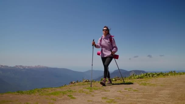 Žena horské turistka s trekking tyče — Stock video