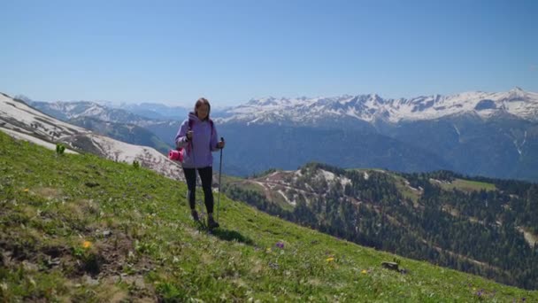 Séta a hegy tetején a nyári napon, fiatal boldog nő hátizsák sétál egyedül lejtőn — Stock videók