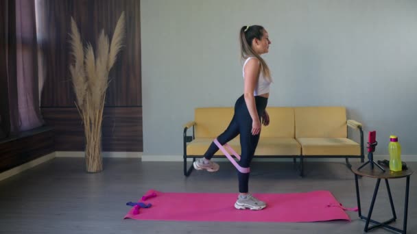 Latihan tubuh bagian bawah dengan pita kebugaran elastis di rumah — Stok Video