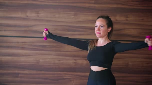 Γυμναστήριο και υγιεινό τρόπο ζωής, η γυναίκα εκπαιδεύεται με ελαφρά αλτήρες — Αρχείο Βίντεο