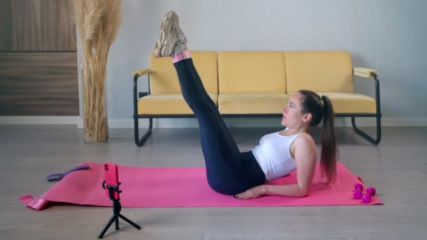 Entrenamiento de fitness en línea en casa, la mujer está grabando vídeo por teléfono inteligente y streaming en la red social — Vídeo de stock