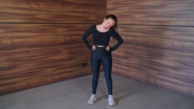 Servikal omurga egzersizi, kadın boynunu çeviriyor, antrenmandan önce kaslarını ısıtıyor.