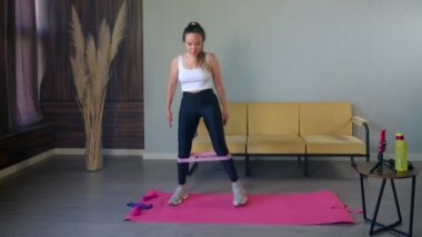 Direniş bandı egzersizleriyle şekillenen bir kadın.