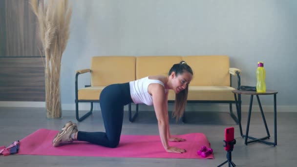 Sportieve vrouw is het filmen van haar ochtend fysieke training met de smartphone voor social networking — Stockvideo