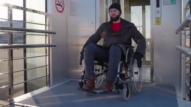 Man in wheelchair got over city stairs with elevator for disabled people — Stock Video