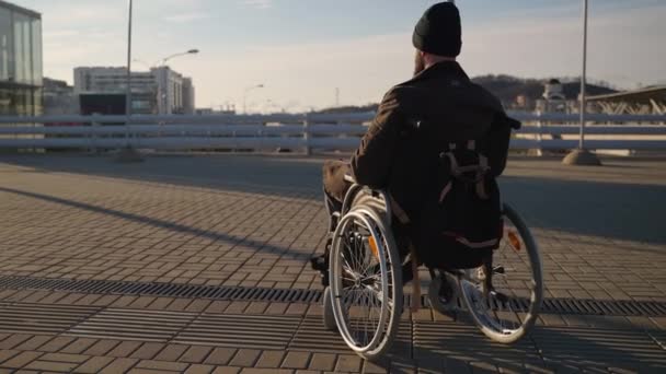 Hombre en silla de ruedas en la ciudad, equipo y accesibilidad para personas con discapacidad en la ciudad moderna — Vídeo de stock