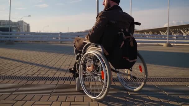 Bărbatul adult stă în scaun cu rotile manual, folosind trăsura nevalidă pentru a se deplasa — Videoclip de stoc
