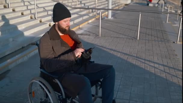 Disabled man texting on mobile being on city stairway — Stock Video
