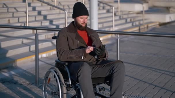 Homme handicapé d'âge moyen envoie un message par smartphone à l'extérieur de la ville — Video