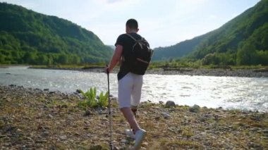 Yaralı, protez bacaklı sporcu doğa yürüyüşünde ve sırt çantasıyla tek başına.