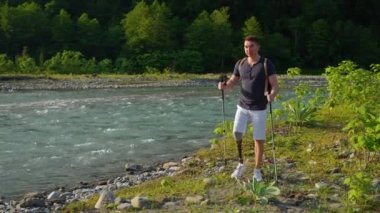 Engelli maceracı nehir boyunca yürüyor.