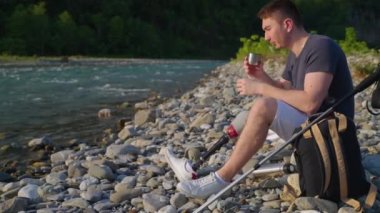 Engelli yürüyüşçü Rocky Nehri kıyısında çay içiyor.