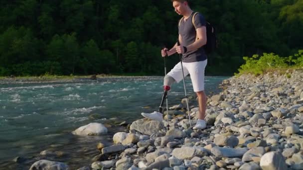 Self-reliant handicapped hiker by the river — Stock Video