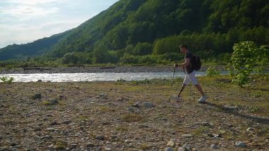 Protez bacaklı erkek turist yaz tatilinde doğa yürüyüşü yapıyor.