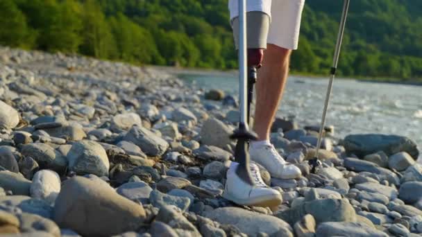 Νεαρός άνδρας χρησιμοποιεί σύγχρονη πρόθεση για το πόδι για το περπάτημα και πεζοπορία, closeup των ποδιών — Αρχείο Βίντεο