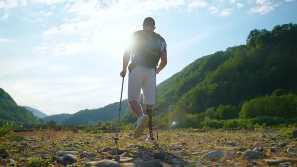 Ung man med protes ben reser ensam i naturen på sommaren — Stockvideo