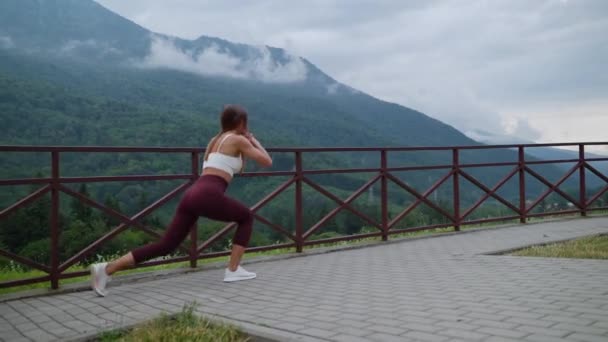 Sporty woman doing lower body exercise outdoor — Stockvideo