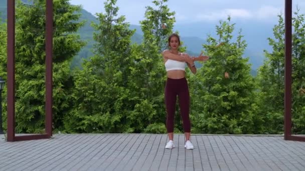 Female fitness instructor is giving free class of exercising in city park — Wideo stockowe