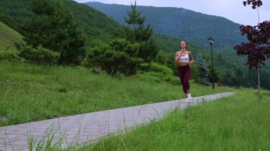 Sportswoman jogging in scenic green park