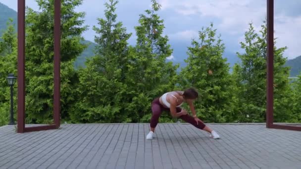 Entraînement d'étirement dans le parc, la femme s'entraîne dans la nature, le réchauffement avant le cours de fitness — Video