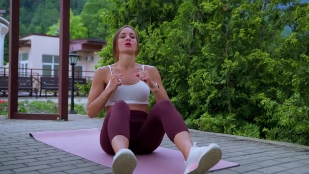 Doing crunches and working abs, sit-ups exercise, woman is training in park — Wideo stockowe