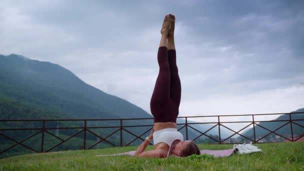 Girl practicing yoga and doing shoulderstand — Stok video