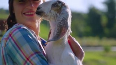 Cheerful village girl with young goat
