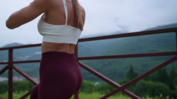 Sporty woman with slender sexy body shape is training outdoors in city — Video