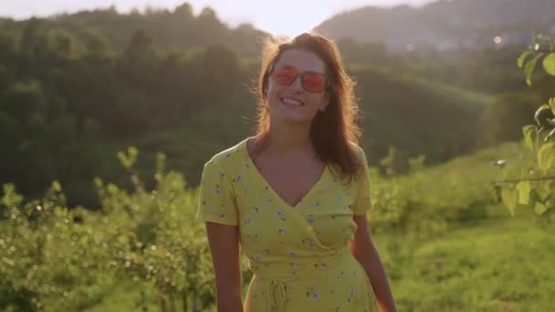 Portrait of pretty smiling brunette in sunny countryside — стоковое видео