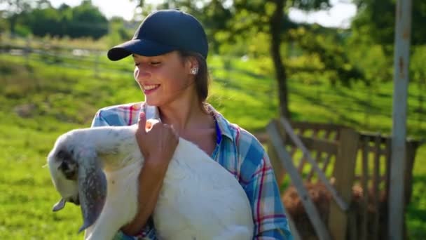 Happy woman farmer with a young goat — Stockvideo