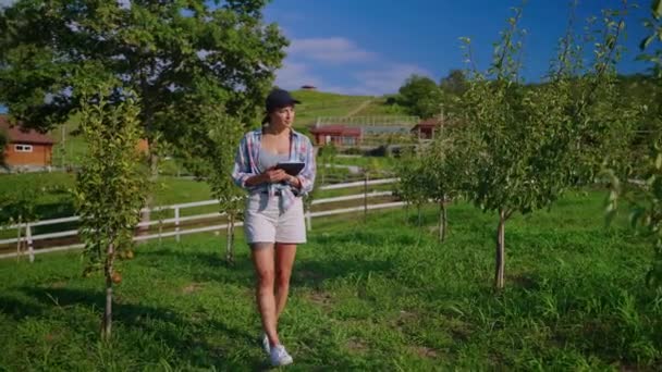 Woman agronomist with tablet computer in the orchard — Stok video