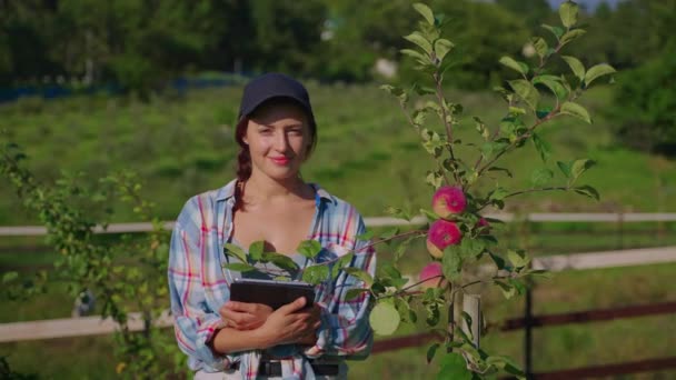 Young female farmer in fruit orchard — Stockvideo