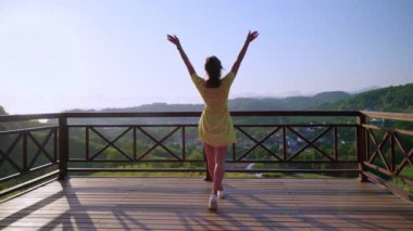 woman is enjoying sunshine and freedom during trip in mountain in summer