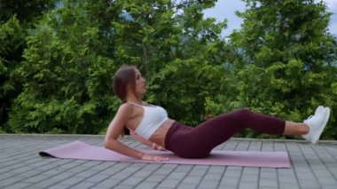 Sportswoman doing abs exercise outdoors
