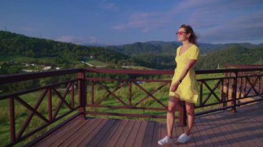 Young woman enjoying countryside scene from house terrace